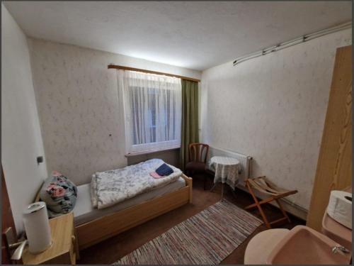 - une petite chambre avec un lit et une fenêtre dans l'établissement Fitnesshotel Bergquell, à Altenau