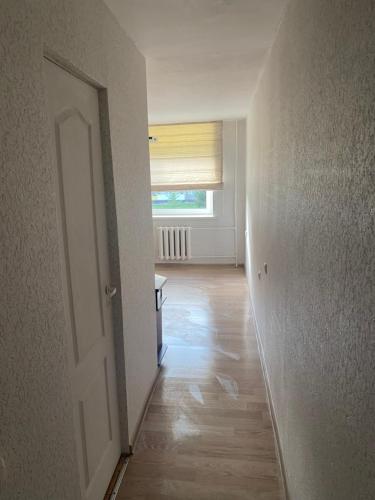 an empty hallway with a door and a window at Mini room in Kėdainiai