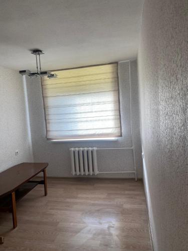 um quarto vazio com uma janela com uma cortina em Mini room em Kėdainiai