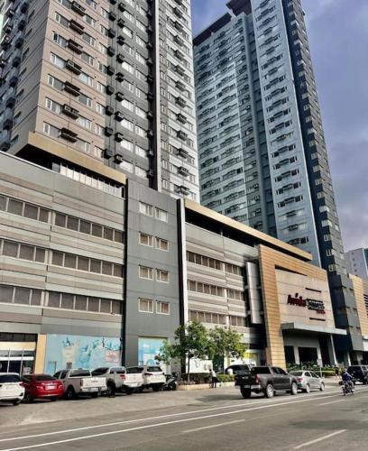 a building with cars parked in front of tall buildings at Avida Towers Davao City by darpm in Davao City