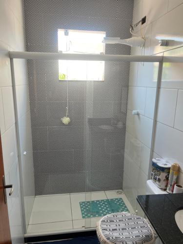 um chuveiro com uma porta de vidro na casa de banho em Casa com piscina para temporada - Unamar, Cabo Frio - RJ em Cabo Frio