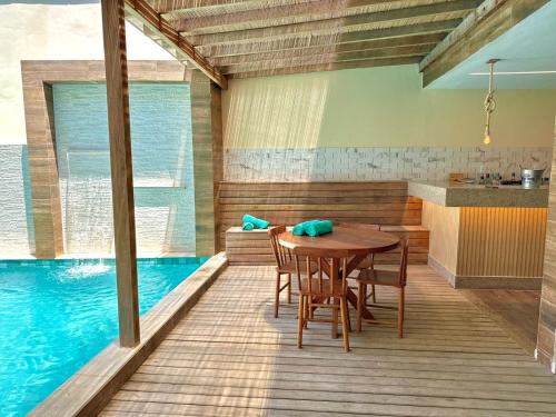 a dining room with a table and a swimming pool at Humaita Pousada in Itacaré