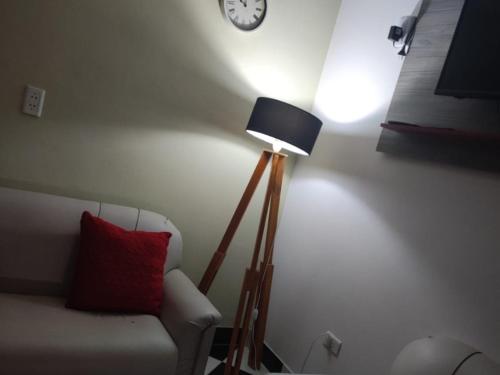 une lampe dans une pièce avec un canapé et un réveil dans l'établissement Temporario Nonogasta, à Nonogasta