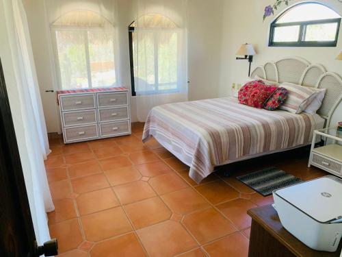 1 dormitorio con 1 cama y suelo de baldosa en 10 Minute Walk to Pickleball and the Sea of Cortez, en Los Barriles