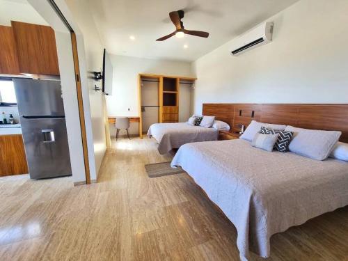 a hotel room with two beds and a refrigerator at Pool Condo, just a few steps from the beach -north in Los Barriles