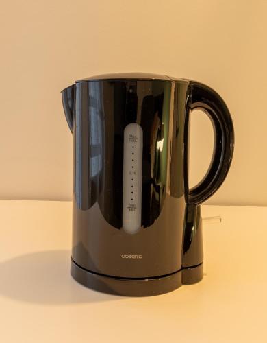 a black coffee pot with a remote control in it at Le Beau Refuge Parisien de Cergy - Parisian modern flat at Cergy in Cergy