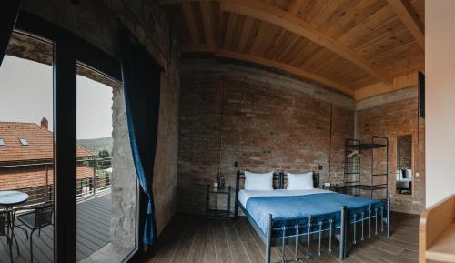 1 dormitorio con 1 cama en una pared de ladrillo en Crama Mircesti 