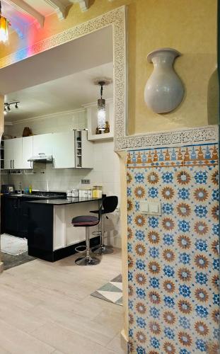 a kitchen with a counter and a table with a chair at DAR AL NOUR in Marrakesh