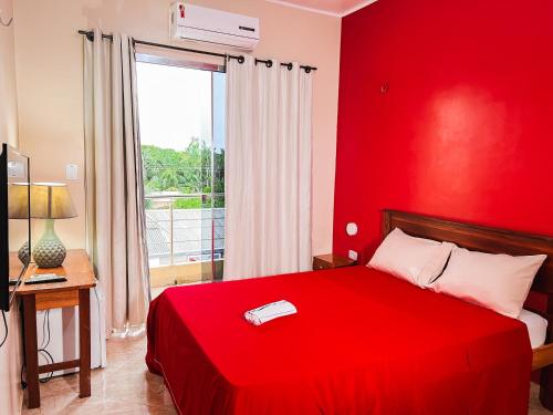um quarto vermelho com uma cama vermelha e uma janela em Hotel fit 