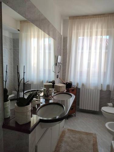 a bathroom with two sinks and two toilets at Ca Bilofer Airport Apartment in Seriate