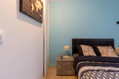 a bedroom with a bed and a table with a lamp at Le Beau Refuge Parisien de Cergy - Parisian modern flat at Cergy in Cergy