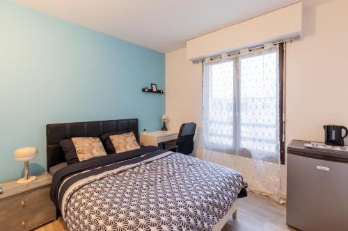 a bedroom with a bed and a desk and a window at Le Beau Refuge Parisien de Cergy - Parisian modern flat at Cergy in Cergy