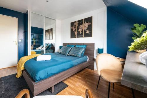 una camera da letto con pareti blu e un letto con lenzuola blu di La Belle Échappée Parisienne - Gare - Hyper Centre a Les Mureaux
