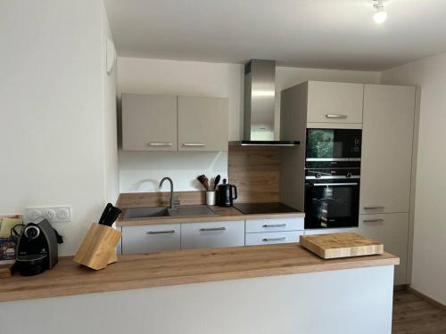 une cuisine avec des armoires blanches et un comptoir dans l'établissement Les Chalets de Montriond B101, à Montriond