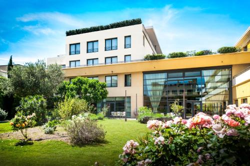 an office building with a garden in front of it at Avignon Grand Hotel in Avignon