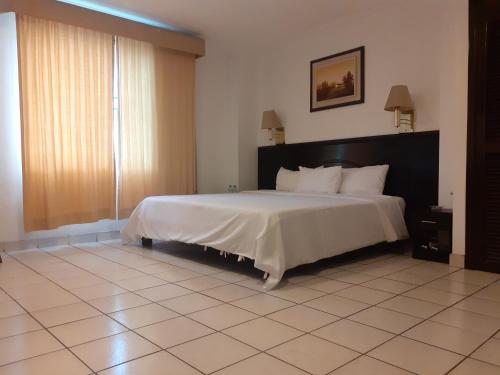 1 dormitorio con 1 cama grande en una habitación en HOTEL DORAL, en Guayaquil