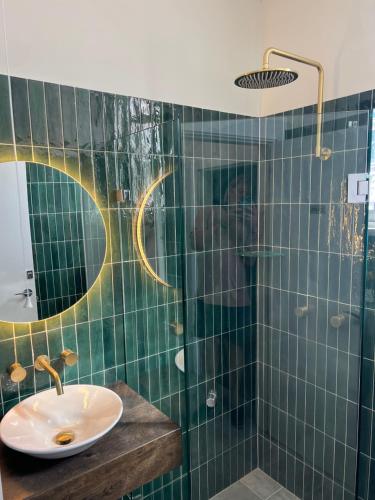 baño de azulejos verdes con lavabo y ducha en Native Rose Hotel en Sídney