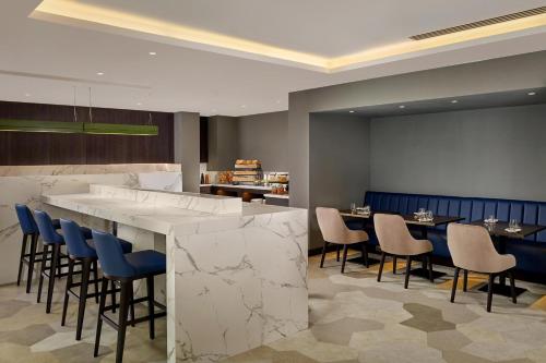 a restaurant with a bar with chairs and tables at Sheraton Grand Hotel & Spa in Edinburgh