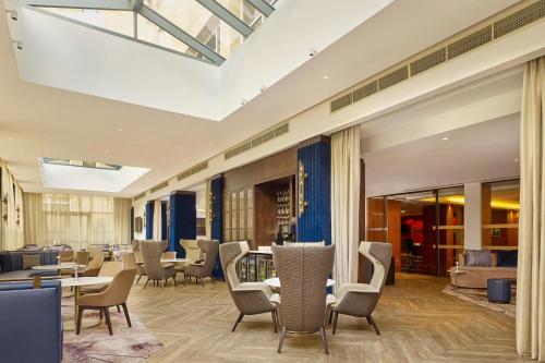 a lobby with chairs and tables in a building at Sheraton Grand Hotel & Spa in Edinburgh