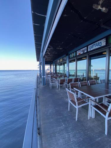 a restaurant with tables and chairs on the water at The Suites at Fishermen's Village - 2 Bedroom Suites in Punta Gorda