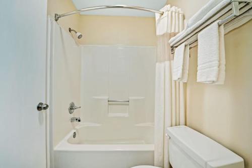 ein weißes Bad mit einem WC und einer Dusche in der Unterkunft Day Star Dallas in Dallas
