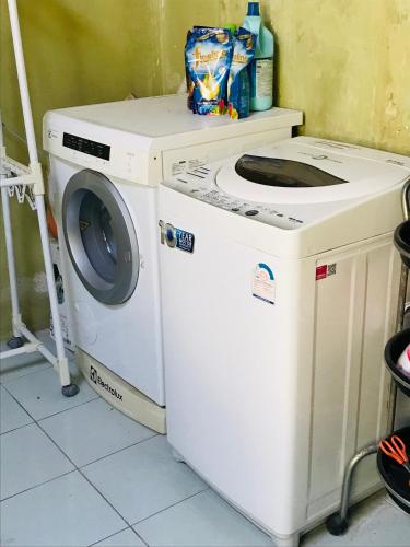 a washing machine sitting next to a washer at Master Bedroom with private bathroom and kitchen in Phuket