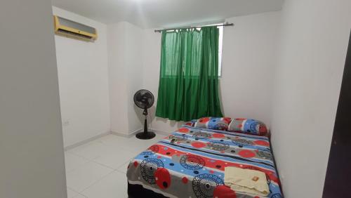 1 dormitorio con 1 cama y cortina verde en Apartamento entero amoblado 201, en Barranquilla