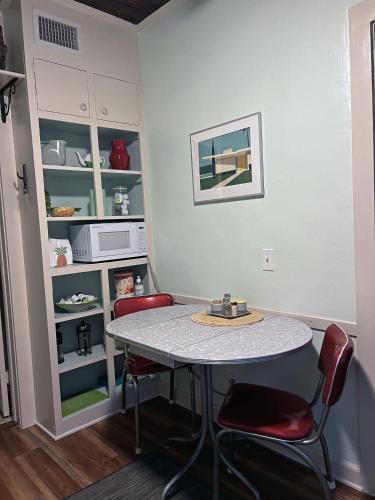 a kitchen with a table and two red chairs at The Cottage at Pineapple House in West Palm Beach