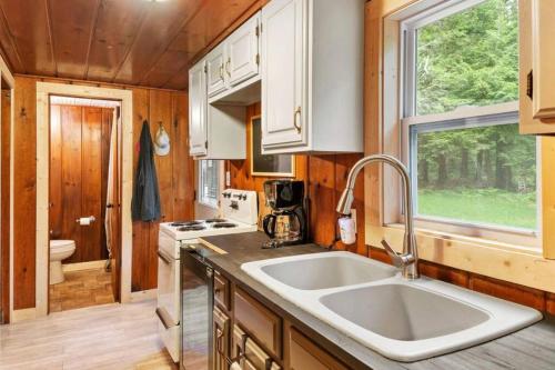 a kitchen with a large sink in a tiny house at Paradise Lake Hidden Gem in Carp Lake