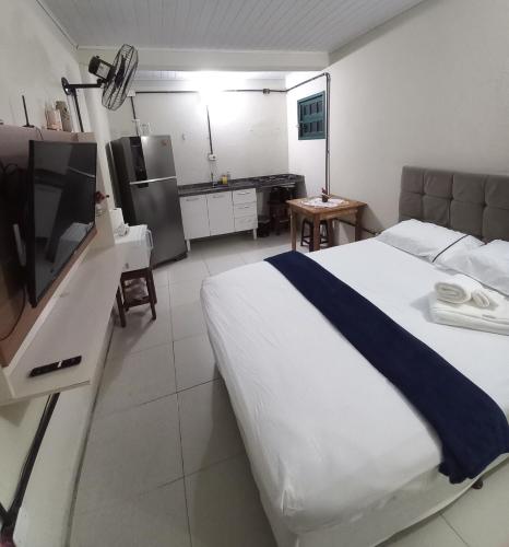 a hotel room with a bed and a television at Condomínio Village Paraty in Paraty