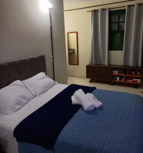um quarto com uma cama com duas toalhas em Condomínio Village Paraty em Paraty