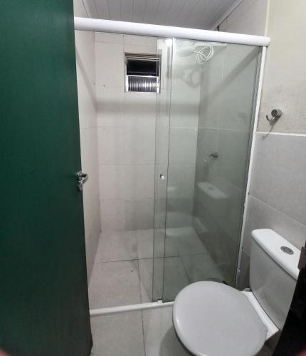 a bathroom with a glass shower with a toilet at Condomínio Village Paraty in Paraty