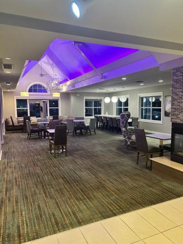 a large room with tables and chairs and purple lighting at ReVi Columbus North in Columbus