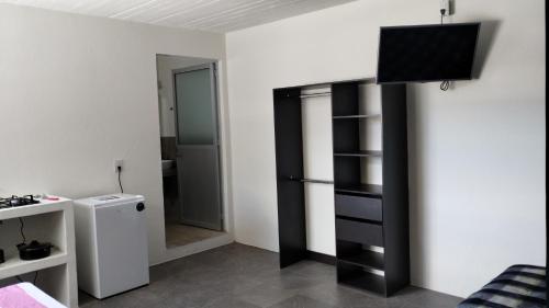 Zimmer mit einem schwarzen Bücherregal und einem Kühlschrank in der Unterkunft Casa mami5 in Oaxaca de Juárez