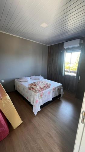 a bedroom with a bed in a room with a window at Recanto Aurora2 in Massiambu Pequeno