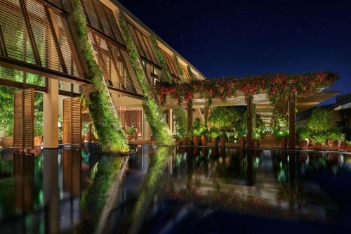 a building with plants on the side of it at night at The Riviera Maya EDITION at Kanai in Playa del Carmen