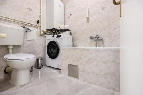 a bathroom with a toilet and a washing machine at White & Bright Escape 1BDR apt in Zagreb