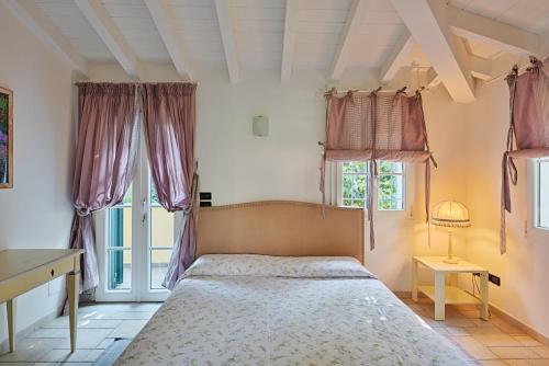 een slaapkamer met een bed en 2 ramen bij Casa Vacanze Nel Giardino di Renzo in Imperia