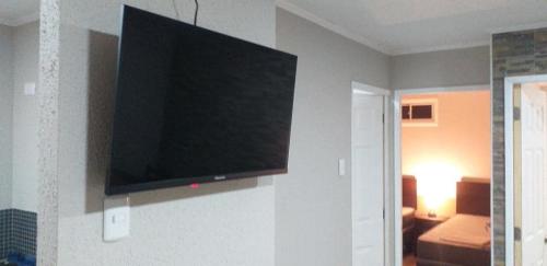 a flat screen tv on a wall in a room at departamentos mirador 2 piso in Caldera