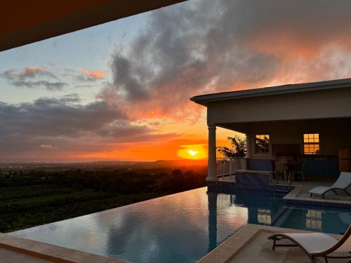 a house with a swimming pool with a sunset at Amaro Villas Barbados Feel like when you're home in Saint Thomas