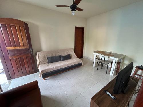 a living room with a couch and a table at Casa na esquina da praia com quintal in Saquarema