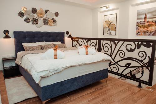 - une chambre dotée d'un grand lit avec un cadre noir dans l'établissement Passage apartment Subotica, à Subotica