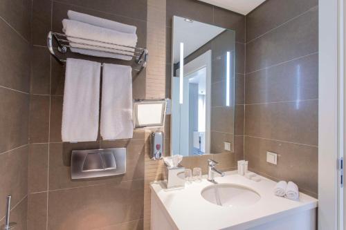 ein Bad mit einem Waschbecken und einem Spiegel in der Unterkunft Radisson Residences Avrupa TEM Istanbul in Istanbul