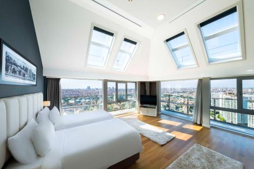 1 dormitorio con cama blanca y ventanas grandes en Radisson Residences Avrupa TEM Istanbul, en Estambul