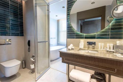 ein Badezimmer mit einem Waschbecken, einem WC und einem Spiegel in der Unterkunft Radisson Hotel Istanbul Sultanahmet in Istanbul