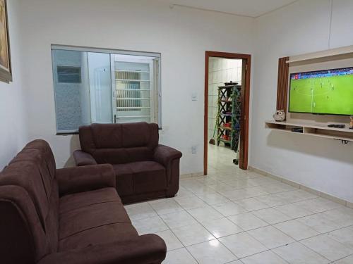 een woonkamer met 2 banken en een flatscreen-tv bij Casa para 12 pessoas perto da Basílica e da Feira in Aparecida