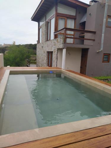 una piscina frente a una casa en Cabañas Agreste en Villa Gesell