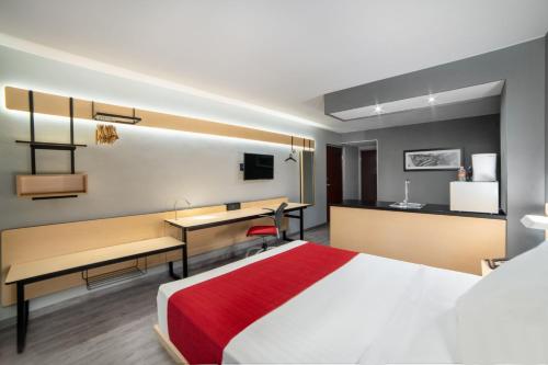 una camera d'albergo con letto e scrivania di City Express by Marriott Puebla Centro a Puebla