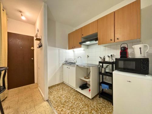 une petite cuisine avec un réfrigérateur et un micro-ondes dans l'établissement Fossati - Tout confort - 5mn à pied du centre ville #SirDest, à Franconville