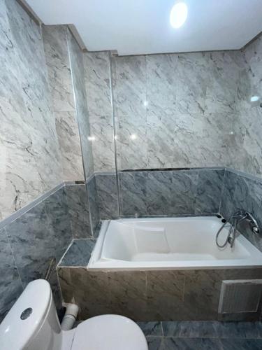 ein Bad mit einer Badewanne und einem WC in der Unterkunft Bel appartement in Tangier
